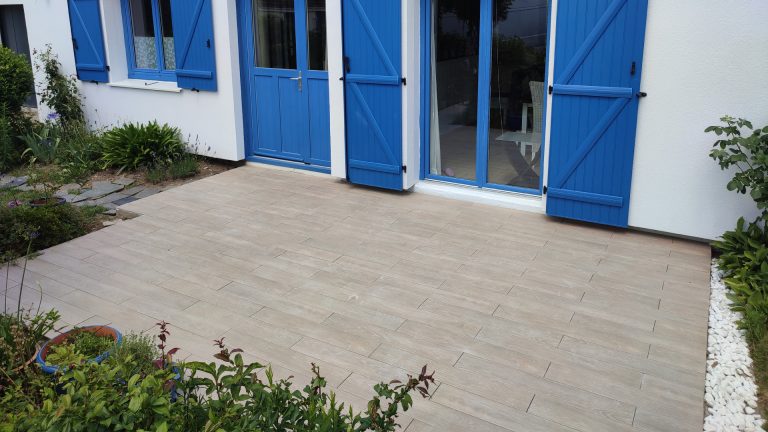 Terrasse carrelée avec maison en fond